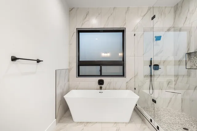 a bathroom with a white tub shower and sink