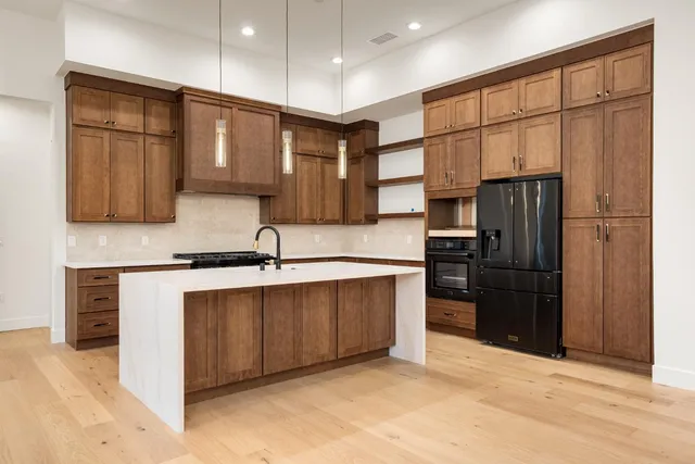 a kitchen with stainless steel appliances granite countertop a refrigerator and a sink