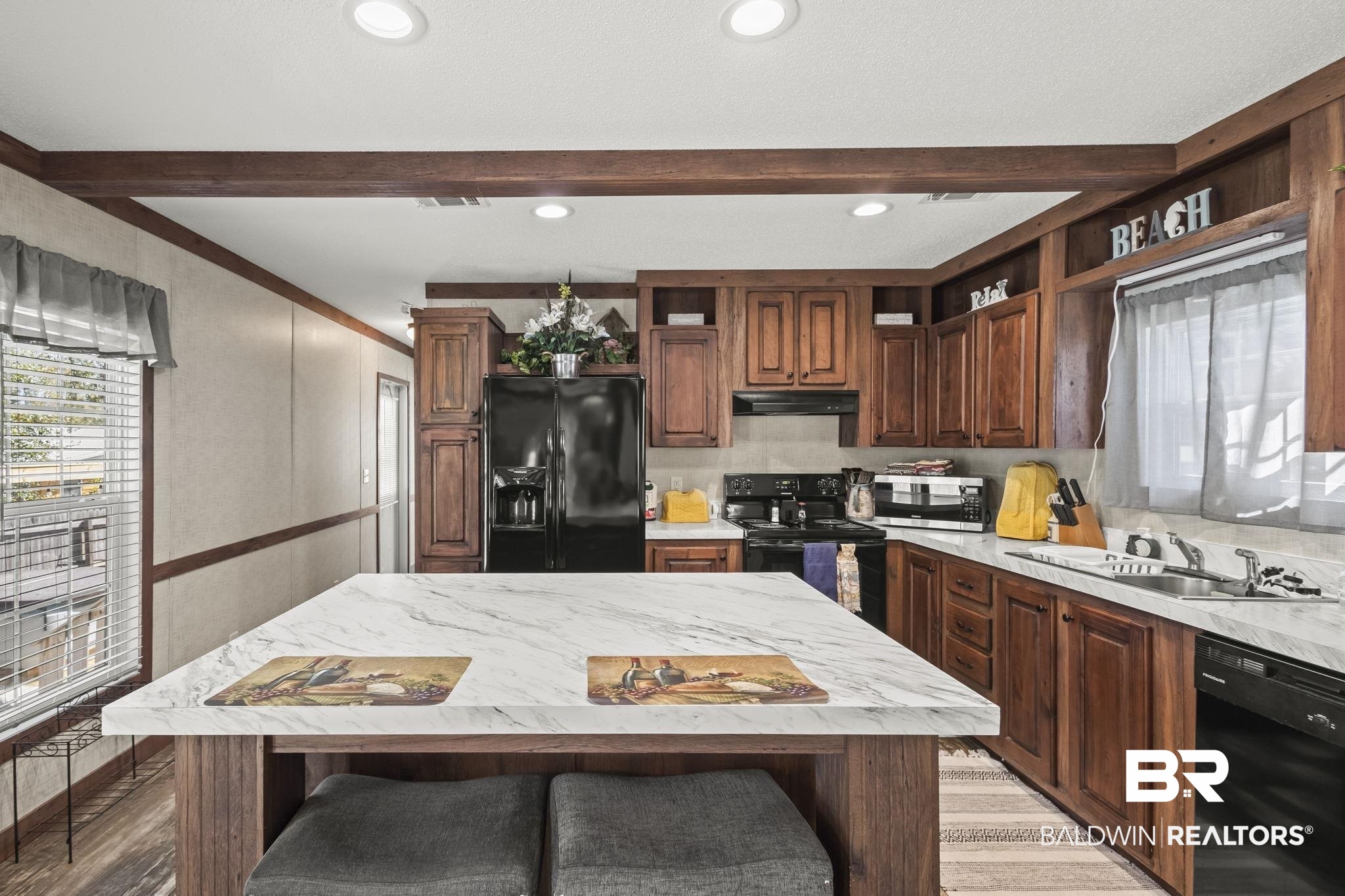 12960 7th Street Lillian, AL 36549 - Photo 19 of 25 Kitchen featuring black appliances, beam ceiling, a sink, and open shelves