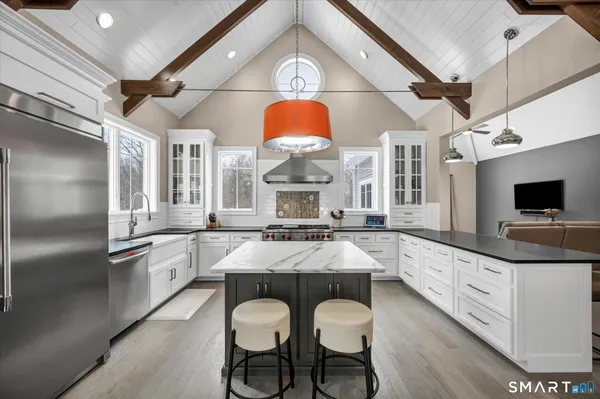 a large kitchen with granite countertop a sink stainless steel appliances and cabinets