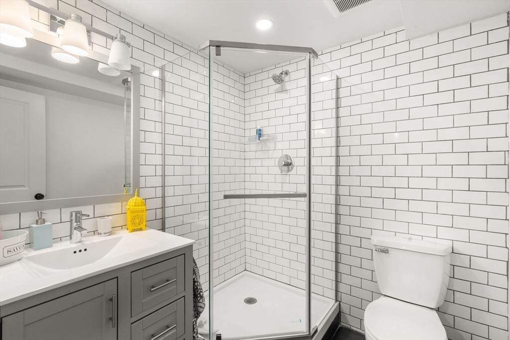 75 Auburn Street Newton, MA 02466 - Photo 28 of 34 a bathroom with a shower a sink mirror and toilet