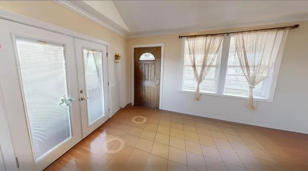 a view of an empty room with window and bathroom