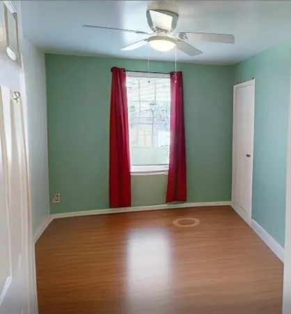 an empty room with windows and fan