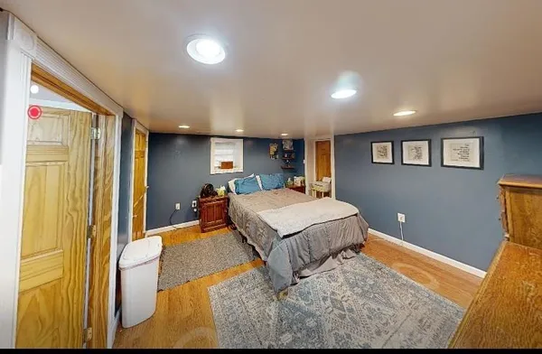 a bedroom with a bed and wooden floor