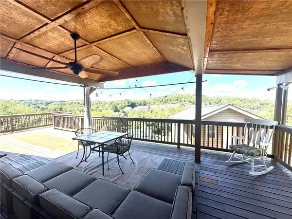 a balcony with wooden floor and outdoor seating