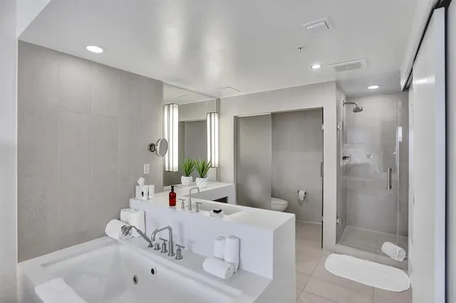 a bedroom with a bed and large windows