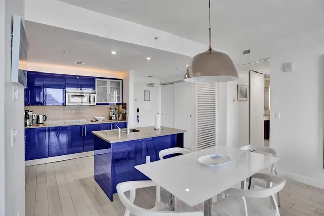 a kitchen with a dining table chairs sink and stove