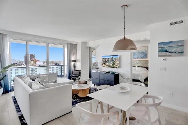 a living room with furniture a table and kitchen view