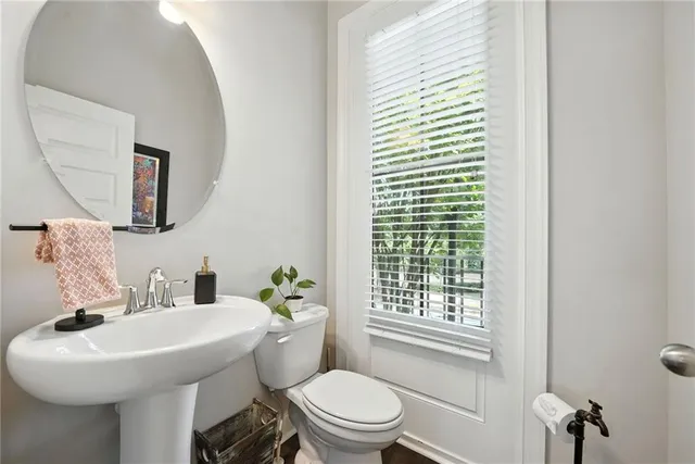 a bathroom with a sink a toilet and mirror