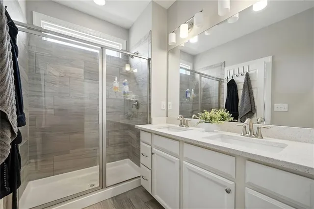 a bathroom with a shower sink and mirror