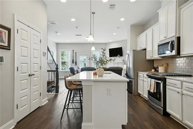 a kitchen that has a lot of cabinets in it and wooden floors