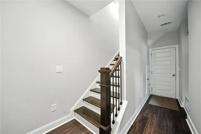 a view of a hallway with wooden floor and staircase