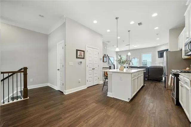 a large kitchen with a table and stainless steel appliances