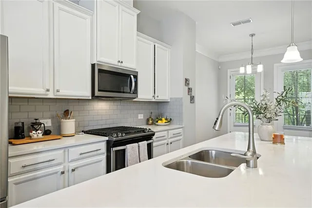 a kitchen with granite countertop a sink a stove and cabinets