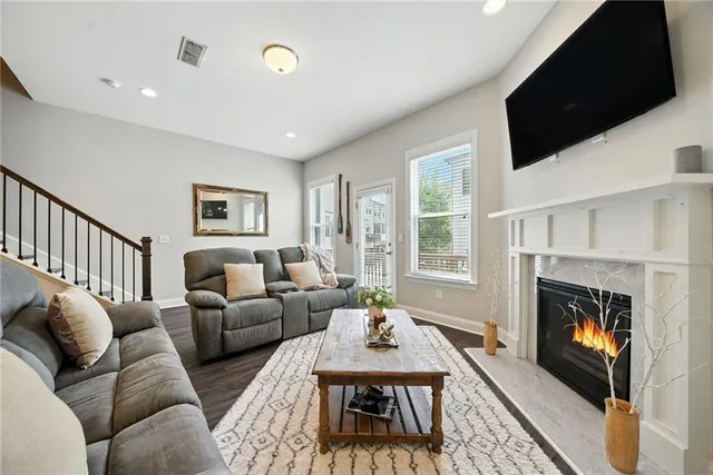 a living room with furniture a flat screen tv and a fireplace