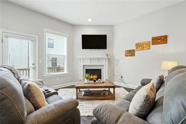a living room with furniture a flat screen tv and a fireplace