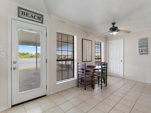 a dining room with furniture and chandelier fan