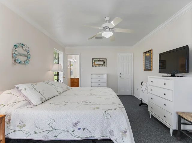 a bedroom with a bed and a flat tv screen on dresser