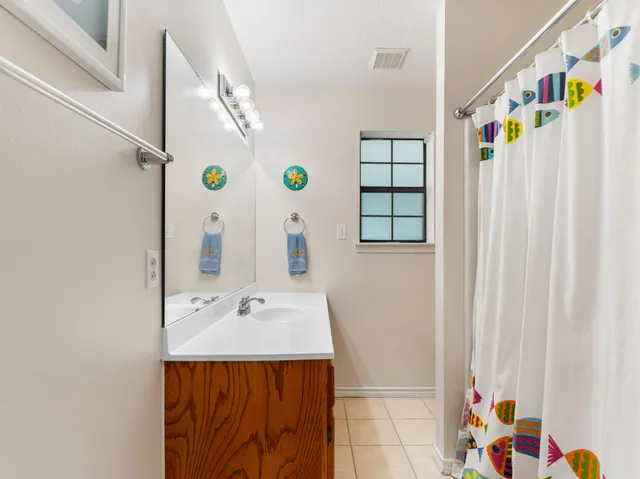 a bathroom with a sink a mirror and a shower curtain