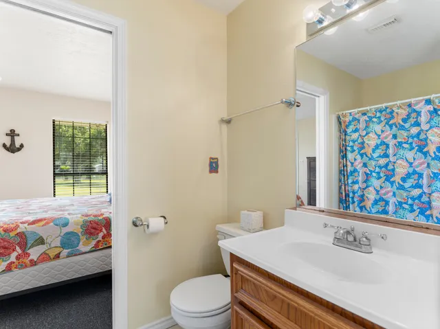 a bathroom with a sink a toilet and shower curtain