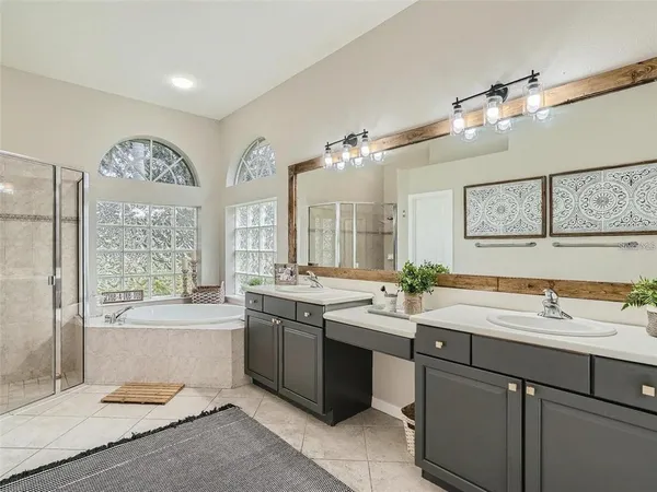 a bathroom with a tub a sink and mirror