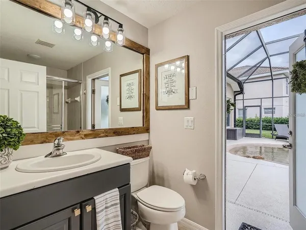 a bathroom with a sink a toilet a mirror and shower