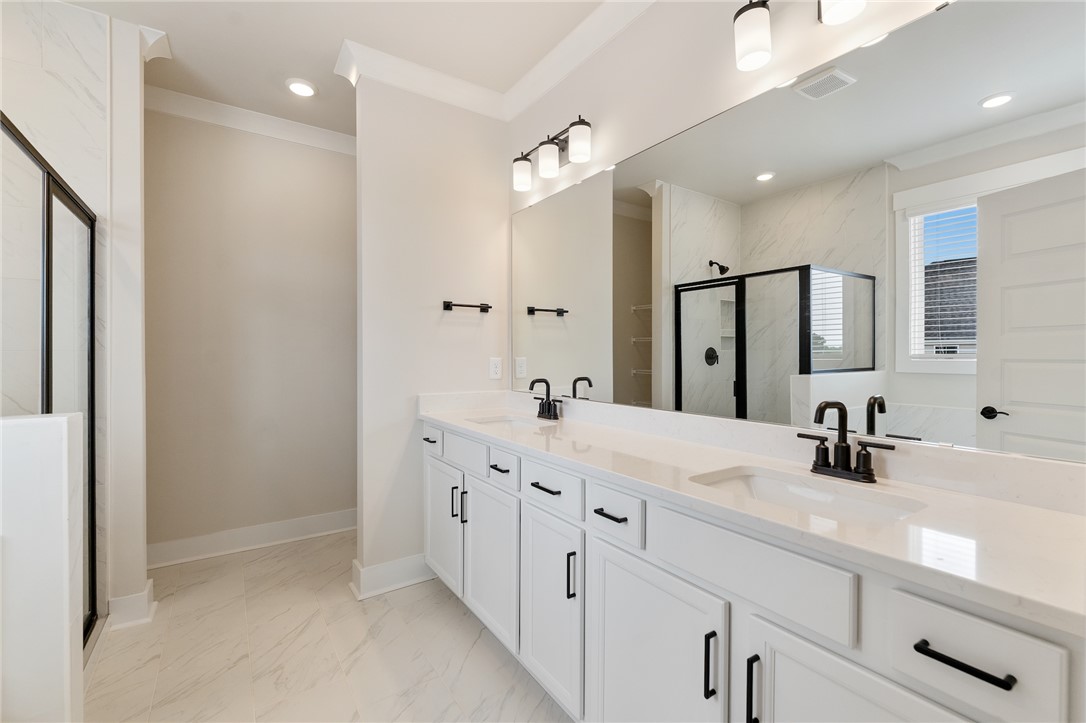 310 Bluestem Court Anderson, SC 29621 - Photo 24 of 36 This spacious owners bath offers a double vanity and a glass-enclosed shower and garden tub creating a serene and functional space.