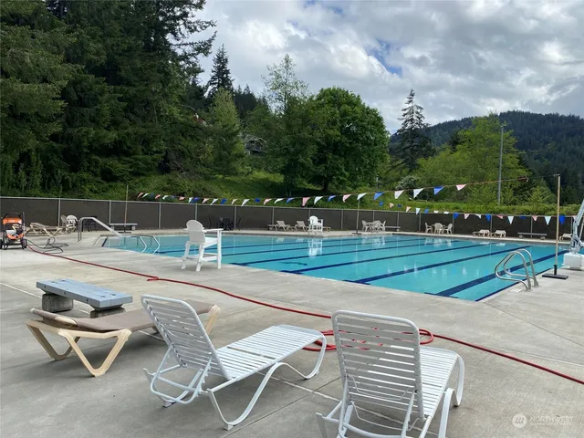 a view of a swimming pool with a yard and palm trees