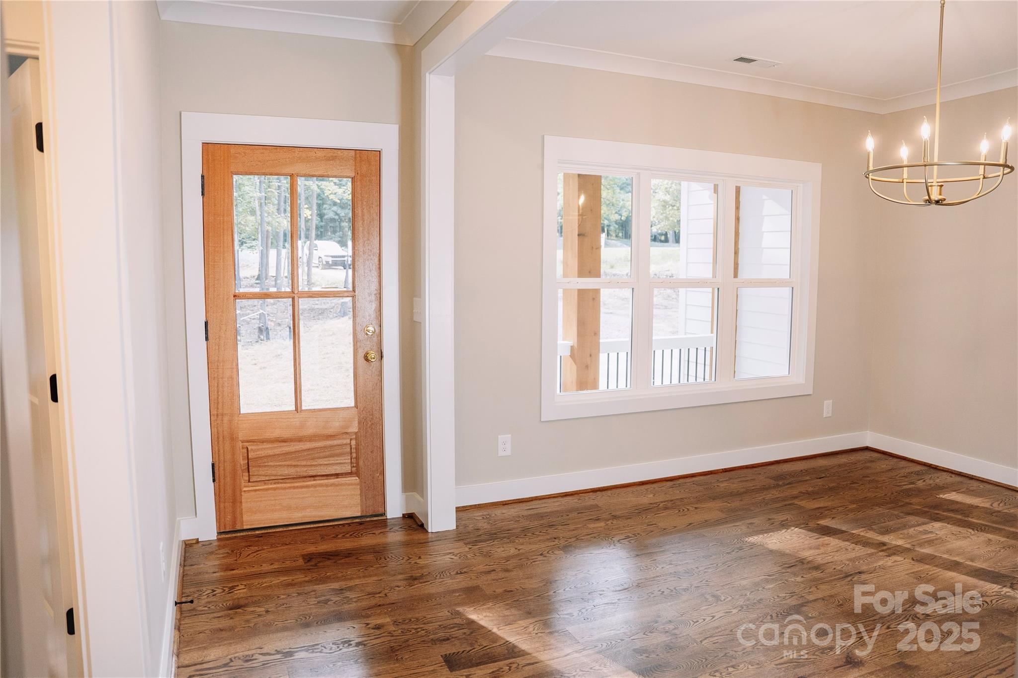 1004 East Sandy Ridge Road Monroe, NC 28112 - Photo 5 of 25 an empty room with wooden floor and windows
