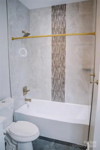 a white bath tub sitting next to a white toilet and sink