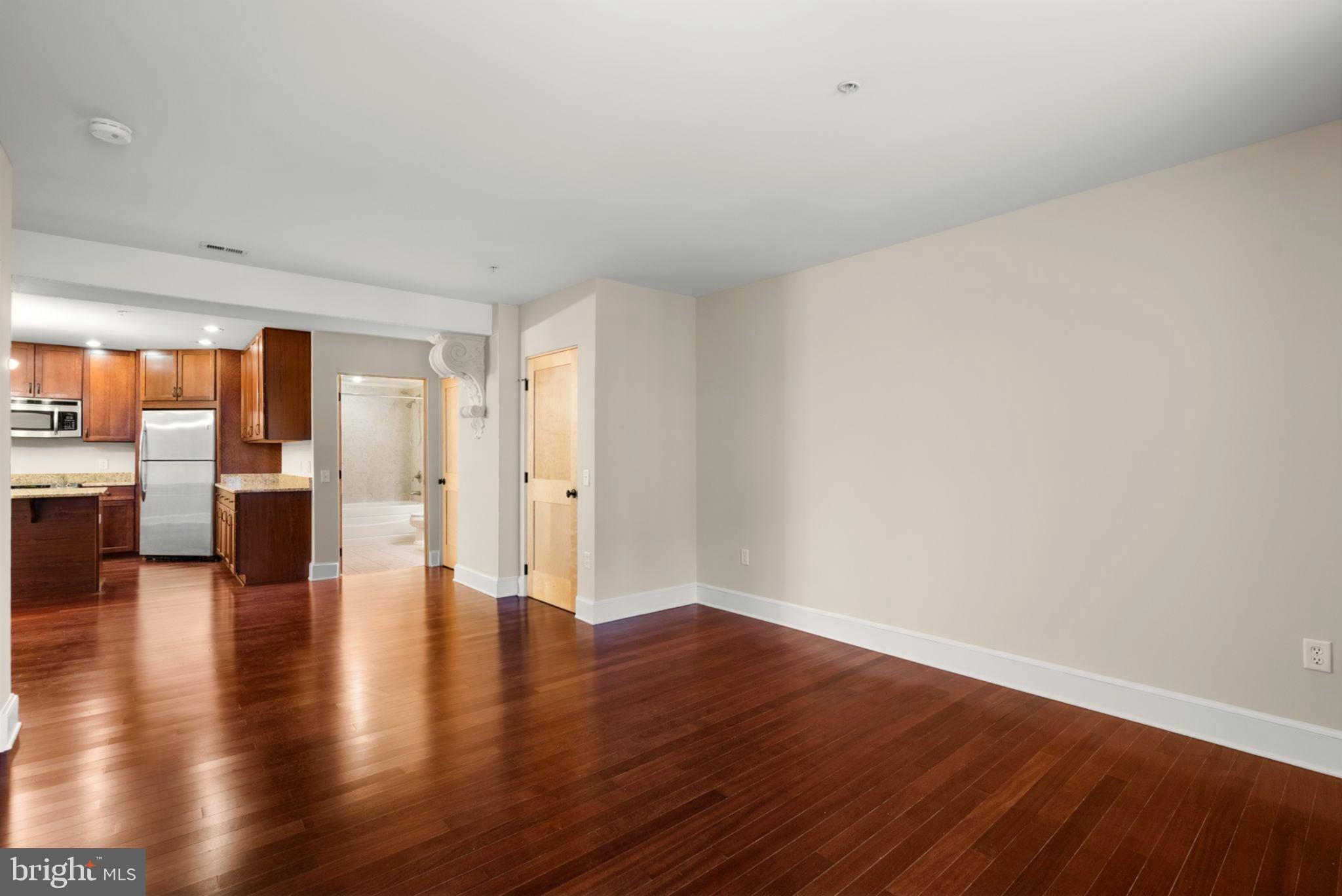 9610 Dewitt Drive, Unit B106 Silver Spring, MD 20910 - Photo 13 of 33 a view of empty room with wooden floor and windows