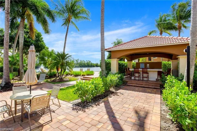 a view of a patio with table and chairs potted plants and palm tree