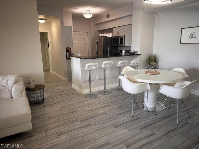 1205 Reserve Way, Unit 308 Naples, FL 34105 - Photo 3 of 21 a living room with furniture and a wooden floor