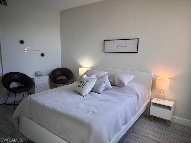 1205 Reserve Way, Unit 308 Naples, FL 34105 - Photo 10 of 21 a large bed sitting in a bedroom and lamp