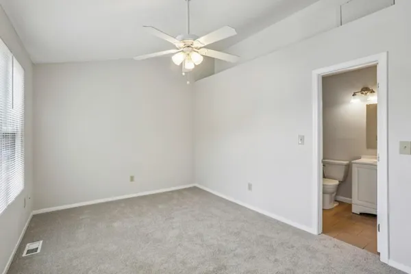 an empty room and a bathroom with a sink