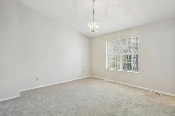 en empty room with windows and chandelier fan