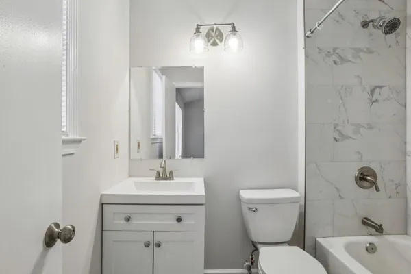 a bathroom with a toilet sink shower and mirror