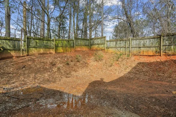 a view of backyard with wooden fence