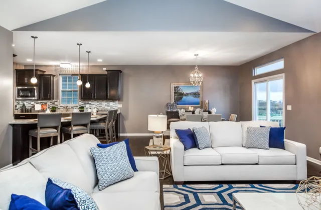 a living room with furniture kitchen and a chandelier