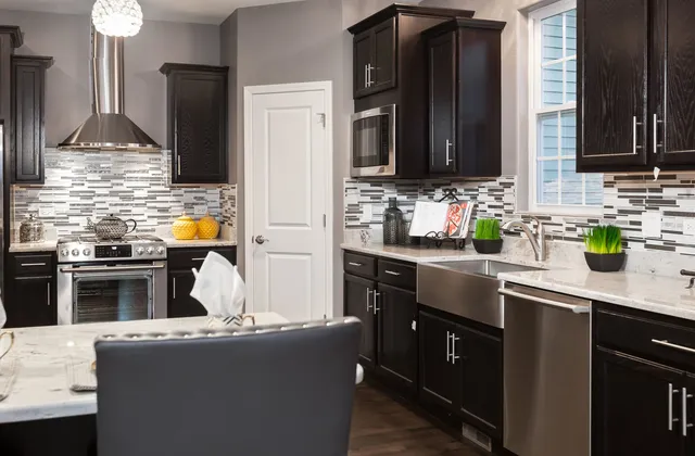 a kitchen with stainless steel appliances kitchen island granite countertop a sink stove and refrigerator