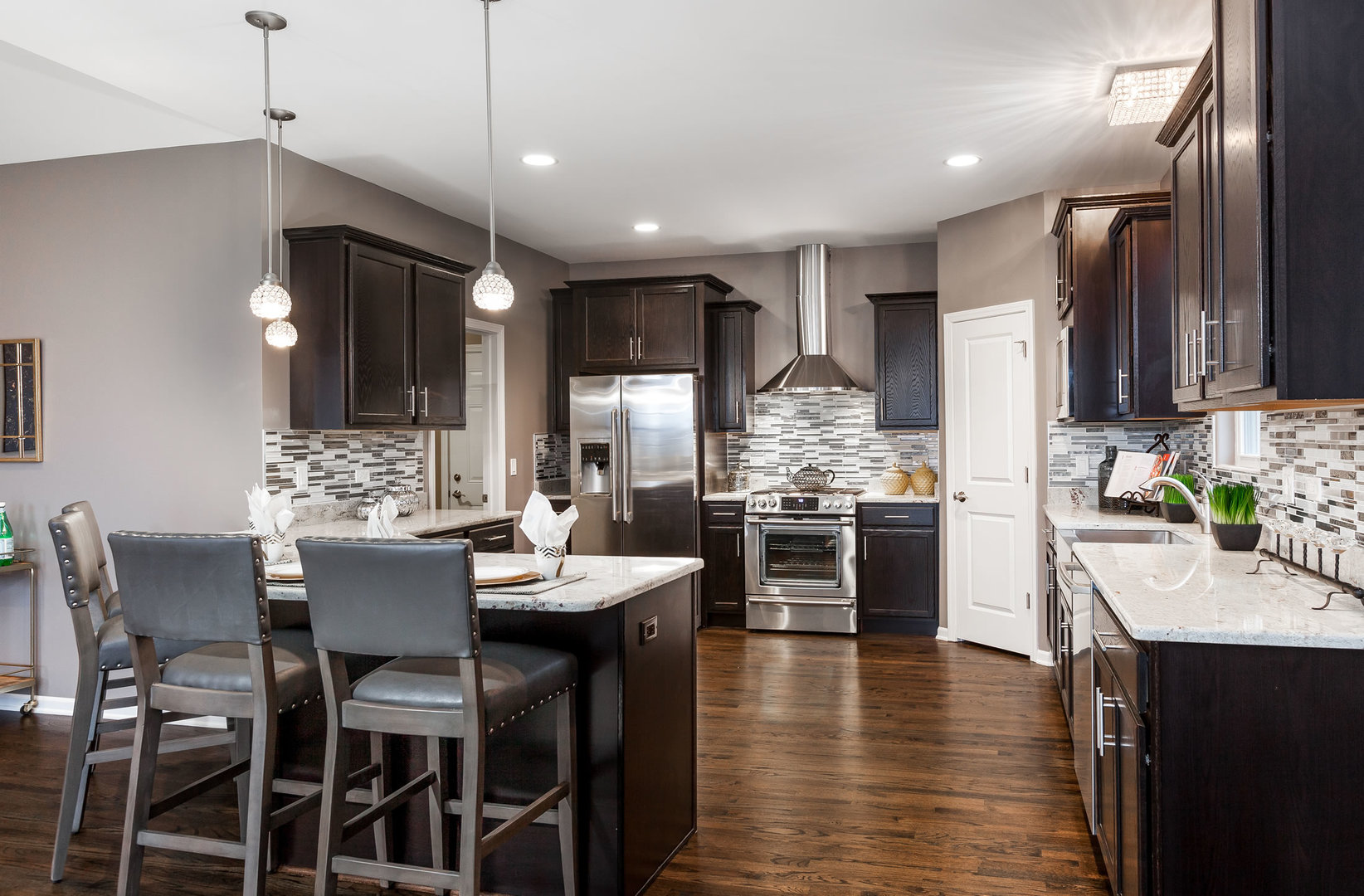 2831 Rood Street Yorkville, IL 60560 - Photo 8 of 17 a kitchen with stainless steel appliances kitchen island granite countertop a stove top oven a sink a dining table and chairs with wooden floor