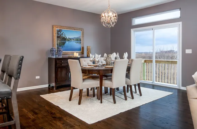 a dining room with wooden floor a chandelier a wooden table and chairs