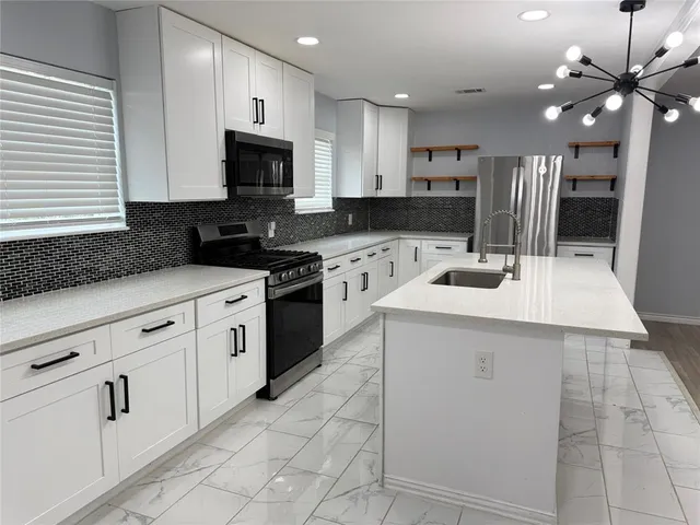 a kitchen with a sink stainless steel appliances and cabinets