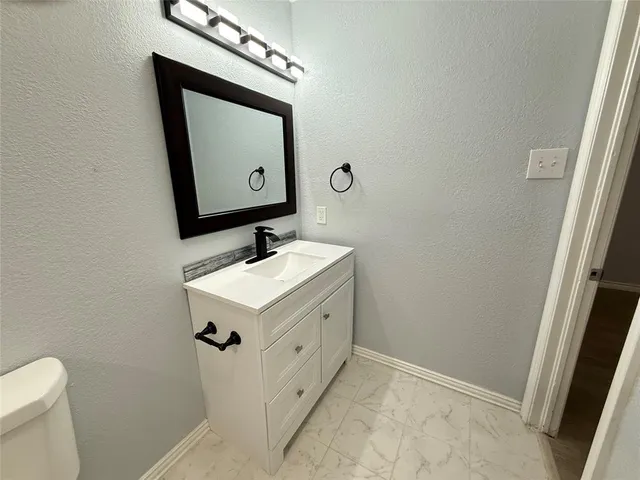 a bathroom with a sink vanity and toilet