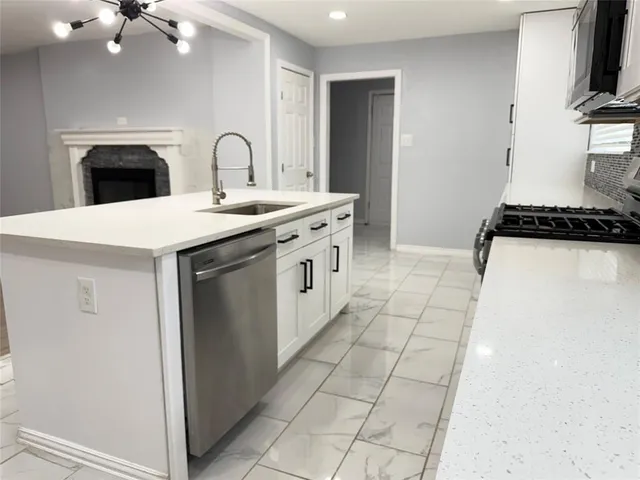 a kitchen with a sink a stove and cabinets