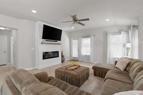 a living room with furniture a flat screen tv and a fireplace