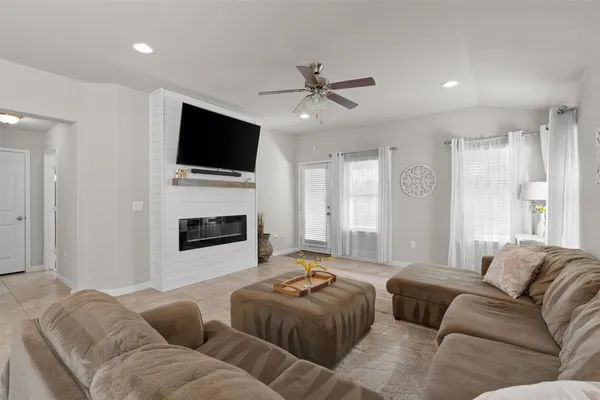 a living room with furniture a flat screen tv and a fireplace