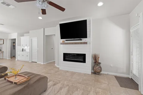 a living room with furniture a flat screen tv and a fireplace