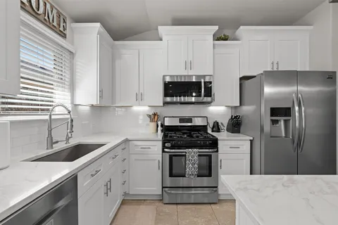 a kitchen with cabinets stainless steel appliances and sink