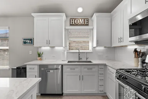 a kitchen with stainless steel appliances granite countertop a sink and a stove